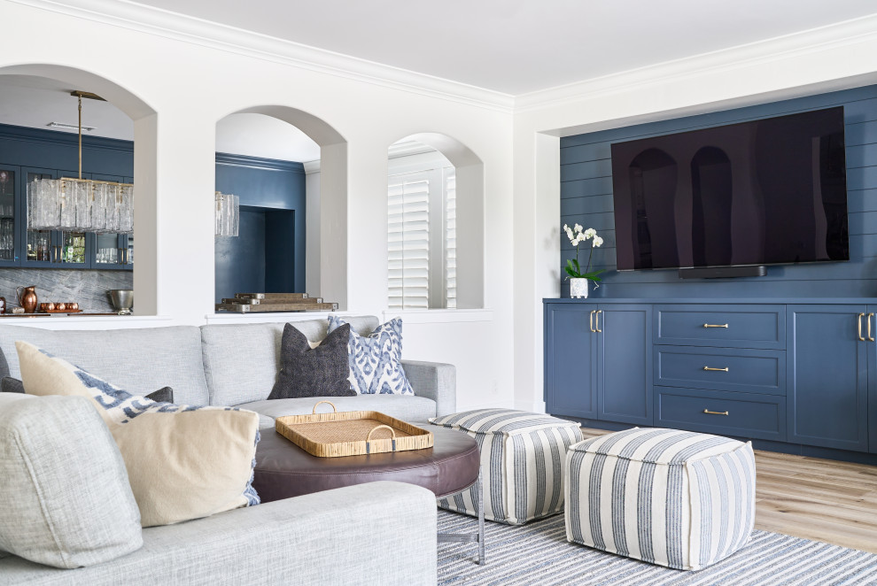 Großes, Offenes Klassisches Wohnzimmer mit blauer Wandfarbe, hellem Holzboden, Kamin, Kaminumrandung aus Backstein, TV-Wand, beigem Boden und Holzdielenwänden in Orange County