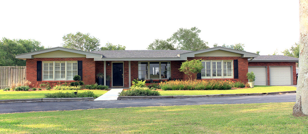 This is an example of a large traditional one-storey brick red exterior in Austin with a gambrel roof.