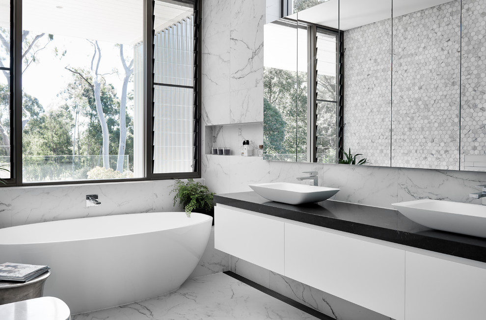 Design ideas for a mid-sized contemporary master bathroom in Sydney with flat-panel cabinets, white cabinets, a freestanding tub, a one-piece toilet, multi-coloured tile, metal tile, multi-coloured walls, marble floors, a vessel sink and multi-coloured floor.
