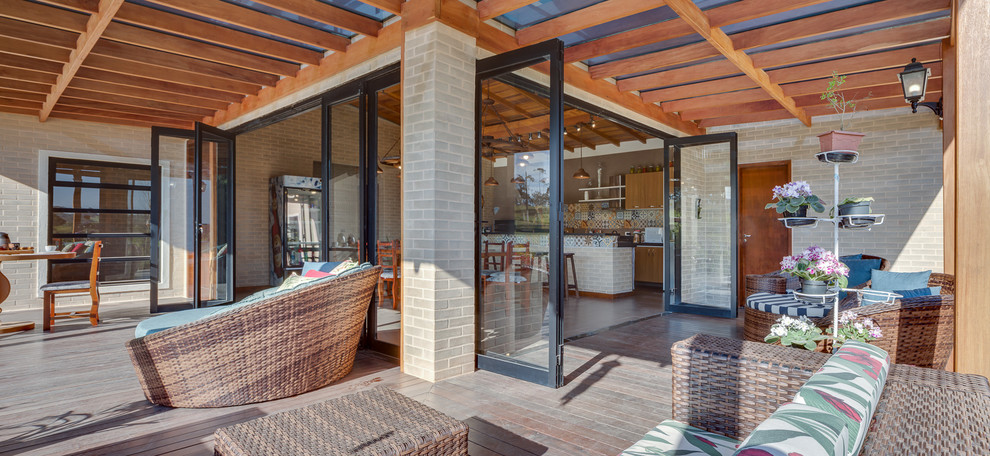 Photo of a mid-sized contemporary front yard verandah in Other with decking and a pergola.