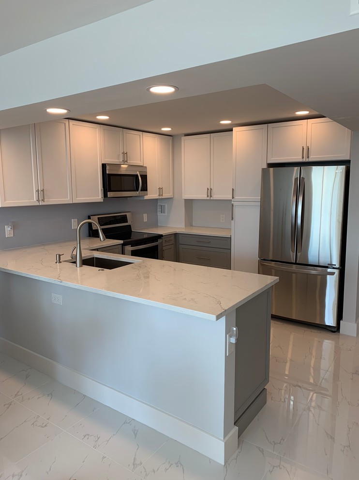 This is an example of a small modern l-shaped open plan kitchen in Miami with an undermount sink, shaker cabinets, grey cabinets, marble benchtops, stainless steel appliances, marble floors, a peninsula, white floor and white benchtop.