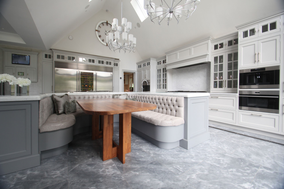 Photo of an expansive traditional l-shaped eat-in kitchen in Buckinghamshire with a drop-in sink, shaker cabinets, grey cabinets, quartzite benchtops, white splashback, marble splashback, stainless steel appliances, marble floors, with island, blue floor, white benchtop and vaulted.