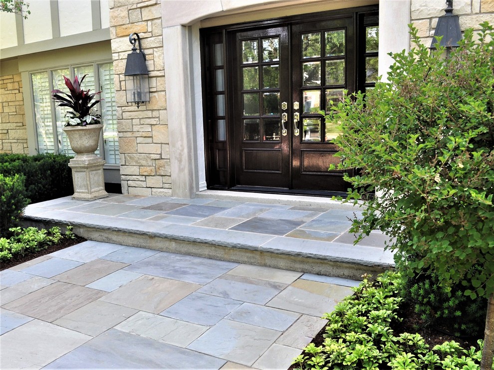 Mid-sized traditional front yard patio in Chicago with natural stone pavers and no cover.