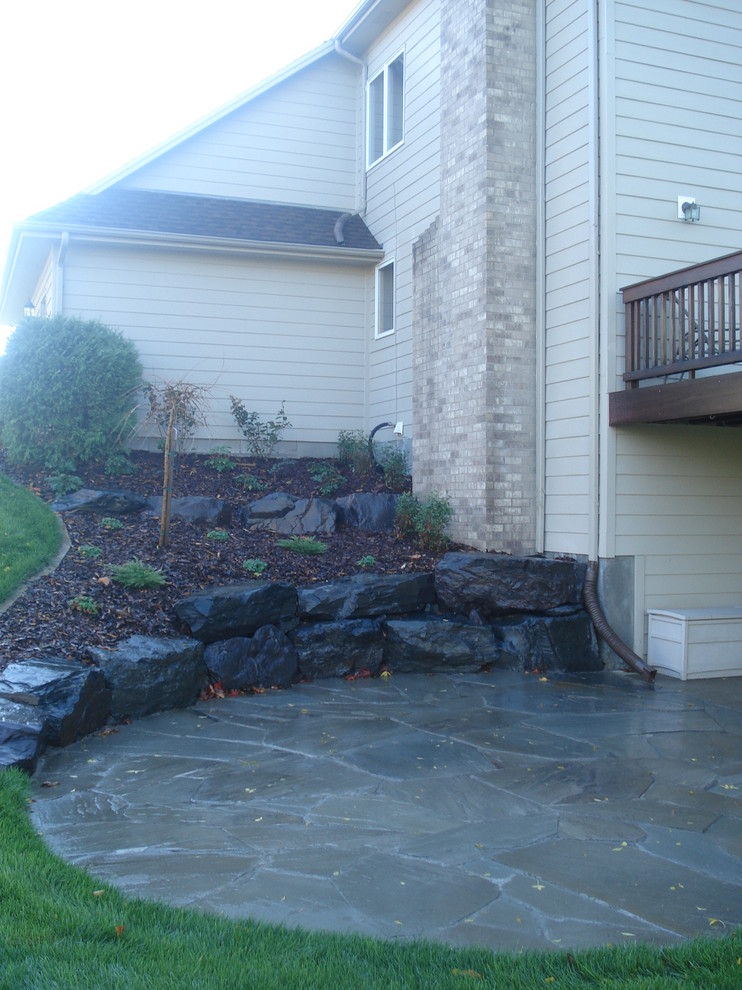 This is an example of a mid-sized traditional backyard patio in Minneapolis with a fire feature, concrete pavers and no cover.