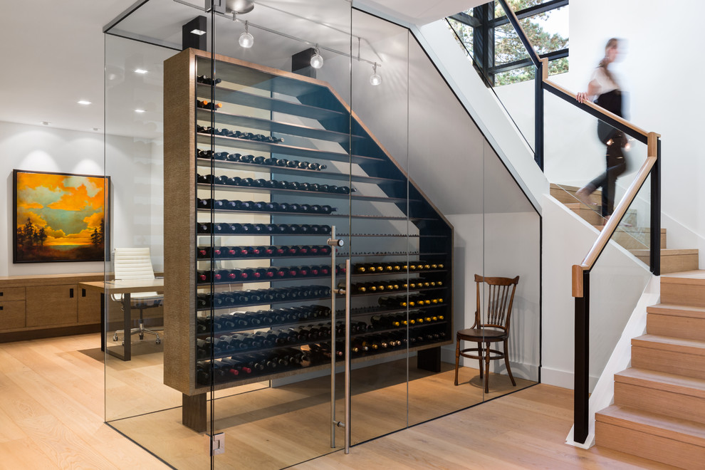 Small contemporary wine cellar in Vancouver with light hardwood floors and storage racks.