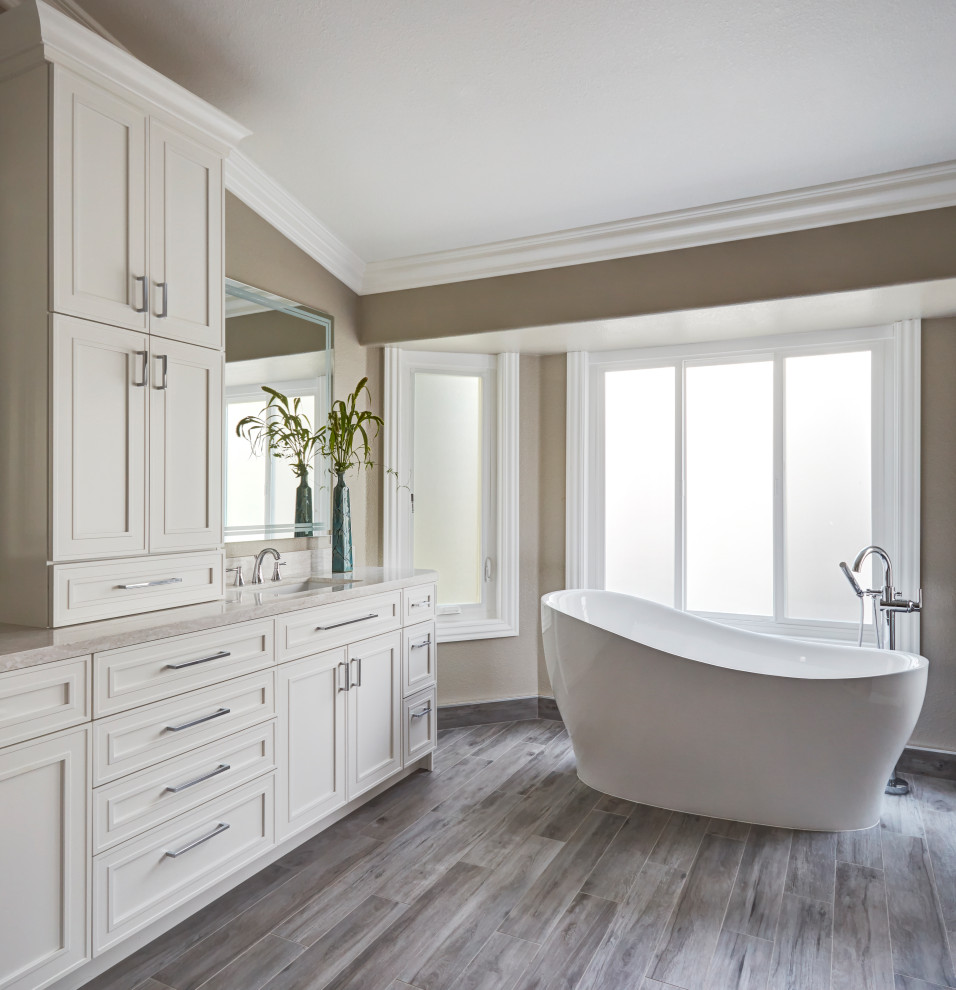 Photo of a large traditional master bathroom in San Francisco with recessed-panel cabinets, white cabinets, a freestanding tub, a corner shower, a one-piece toilet, brown tile, ceramic tile, beige walls, ceramic floors, an undermount sink, engineered quartz benchtops, brown floor, a hinged shower door and white benchtops.