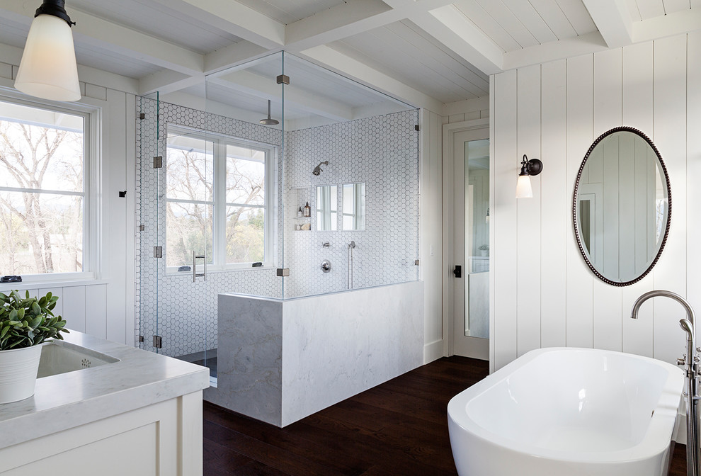 Mid-sized country master bathroom in San Francisco with raised-panel cabinets, white cabinets, a freestanding tub, an open shower, a one-piece toilet, white tile, mosaic tile, white walls, dark hardwood floors, a drop-in sink, granite benchtops and an open shower.