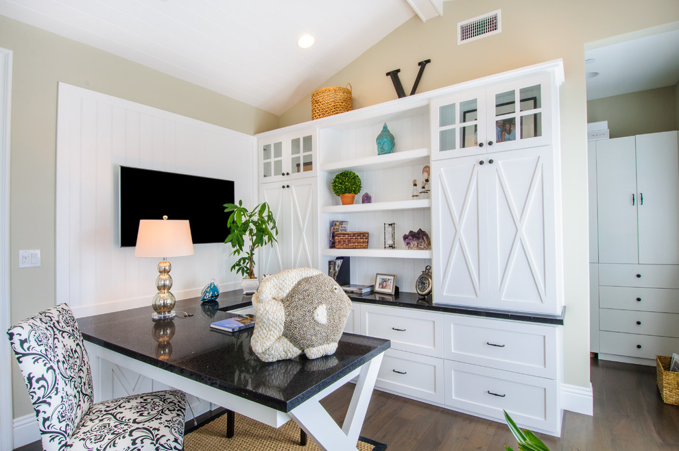 Beach style home office in Los Angeles with beige walls, dark hardwood floors and a built-in desk.