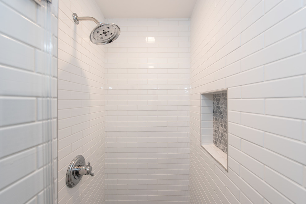 Photo of a small traditional master bathroom in DC Metro with shaker cabinets, dark wood cabinets, an alcove shower, a two-piece toilet, white tile, porcelain tile, grey walls, porcelain floors, a pedestal sink, brown floor and a hinged shower door.
