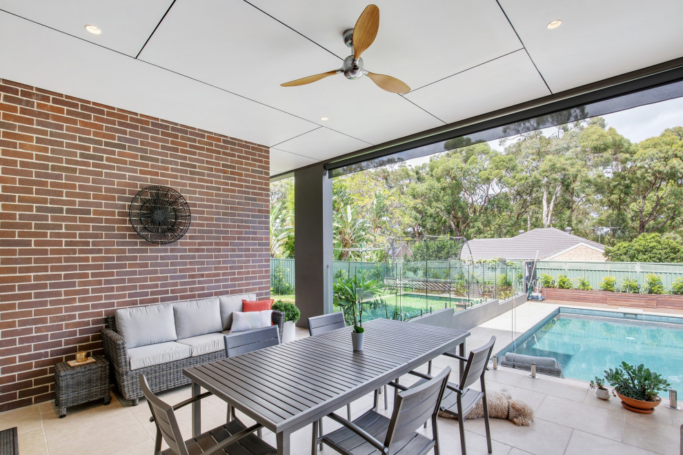 Inspiration for a large transitional backyard patio in Sydney with tile and a roof extension.