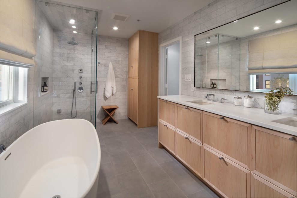 Photo of a transitional master bathroom in Orange County with medium wood cabinets, a freestanding tub, a curbless shower, gray tile, white tile, an undermount sink, engineered quartz benchtops, grey floor, a hinged shower door, white benchtops, a double vanity, a built-in vanity and shaker cabinets.