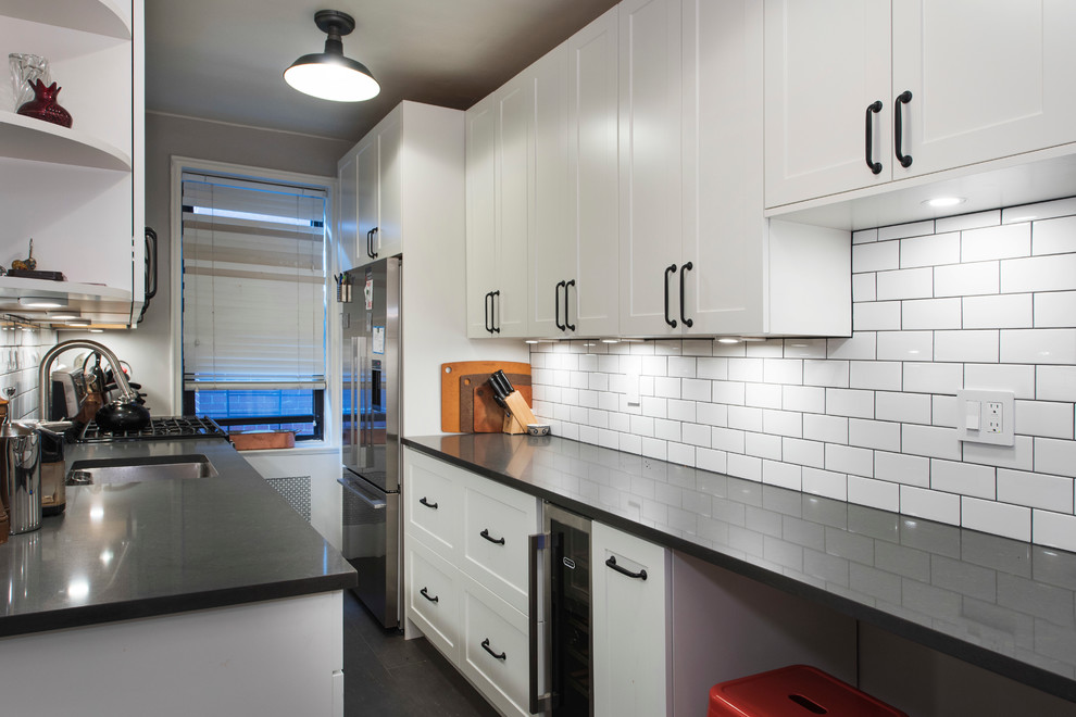Inspiration for a small modern galley separate kitchen in New York with an undermount sink, shaker cabinets, white cabinets, white splashback, subway tile splashback, stainless steel appliances, vinyl floors and no island.