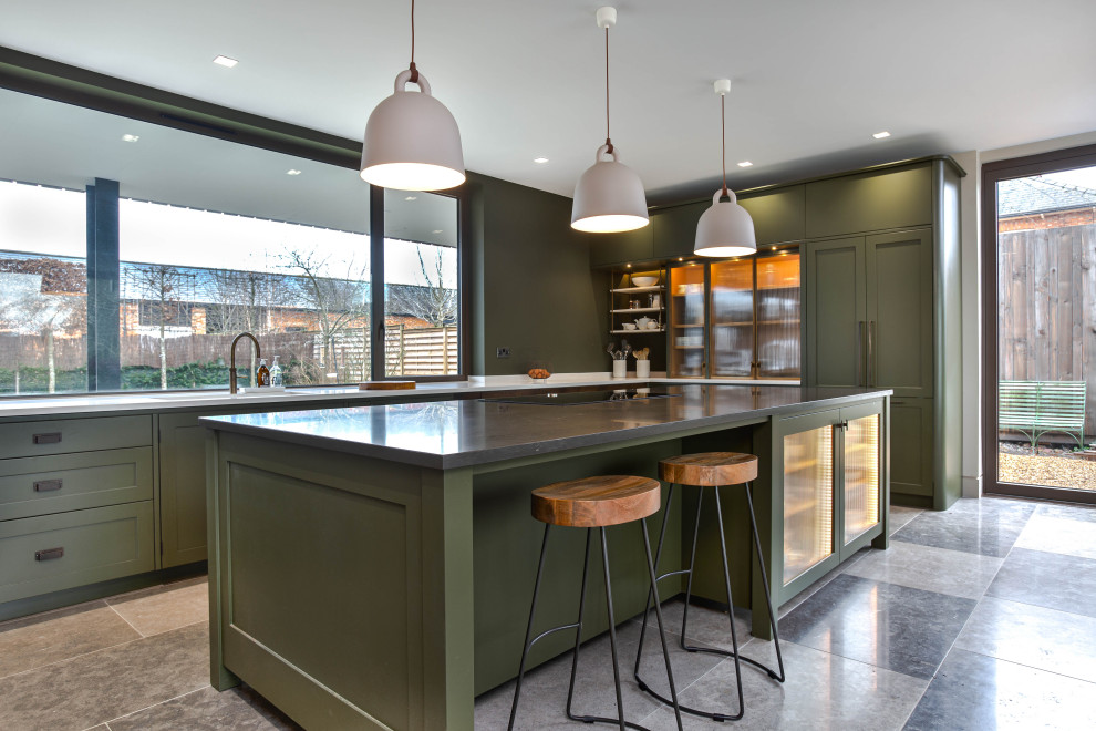 This is an example of a large urban l-shaped open plan kitchen in Cambridgeshire with a double-bowl sink, shaker cabinets, green cabinets, quartz worktops, green splashback, stainless steel appliances, limestone flooring, an island, grey floors and white worktops.