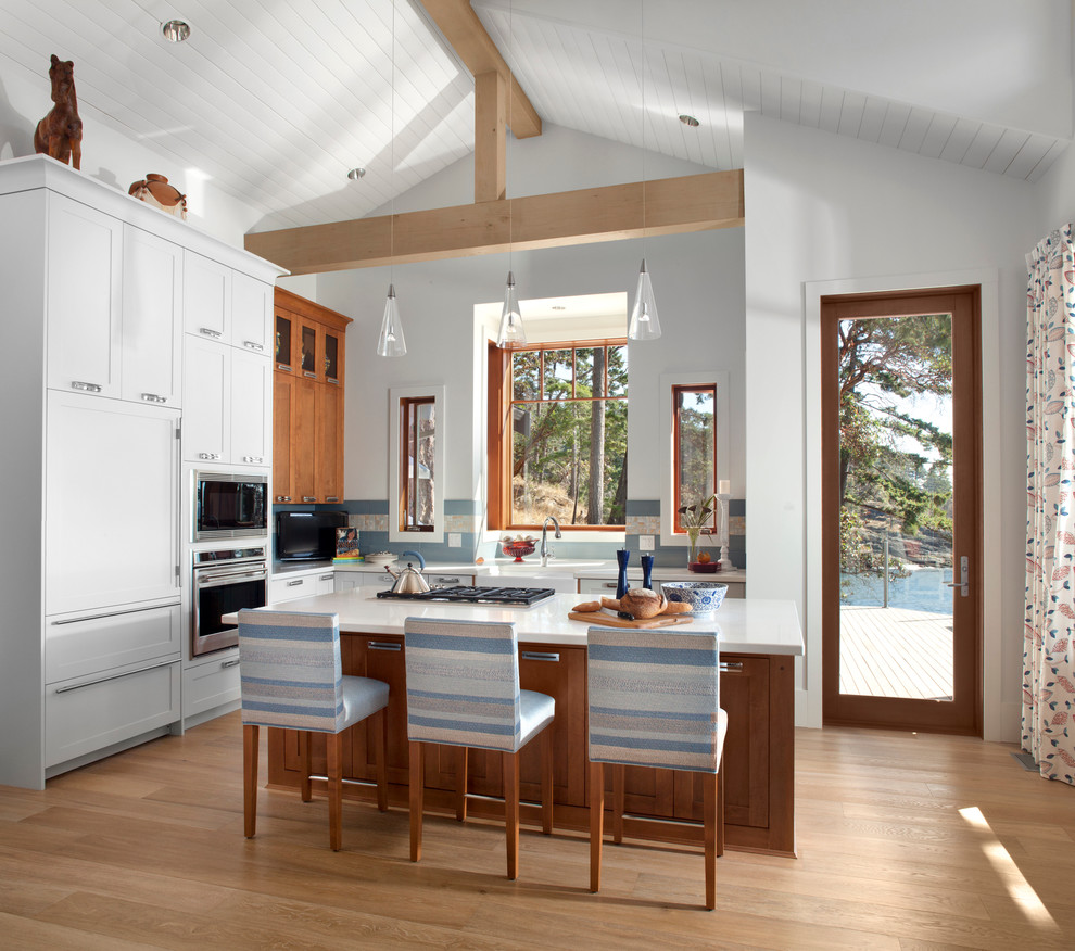 Contemporary l-shaped eat-in kitchen in Vancouver with panelled appliances, shaker cabinets, white cabinets, blue splashback, a farmhouse sink, quartzite benchtops and ceramic splashback.