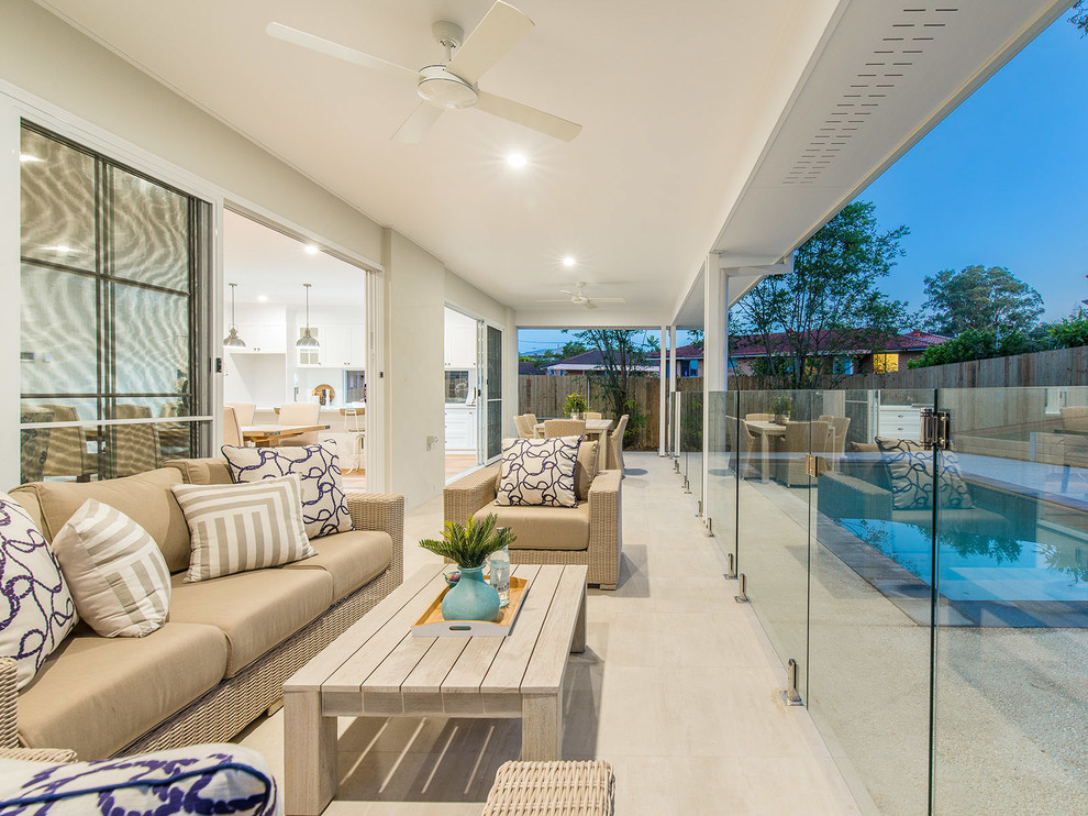 Inspiration for a mid-sized beach style backyard verandah in Brisbane with a roof extension and tile.