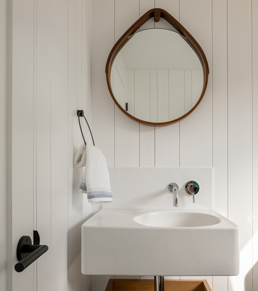 Beach style powder room in Portland Maine with white walls, a vessel sink and planked wall panelling.