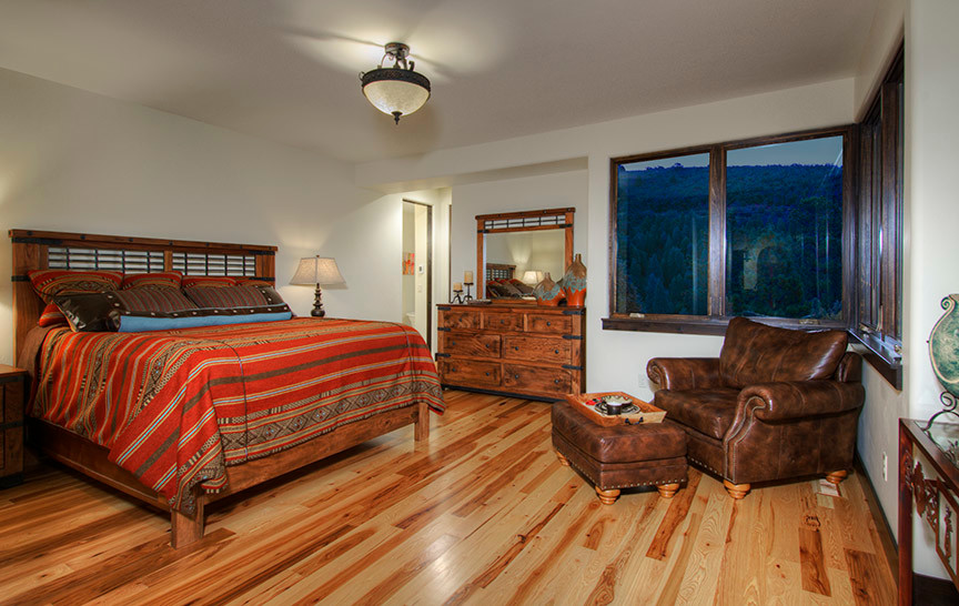 Photo of a large transitional master bedroom in Denver with white walls and light hardwood floors.