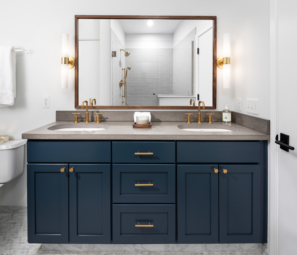 Design ideas for a mid-sized eclectic master bathroom in Detroit with recessed-panel cabinets, an alcove shower, white walls, a hinged shower door, grey benchtops, blue cabinets, gray tile, marble floors, a drop-in sink, grey floor and concrete benchtops.