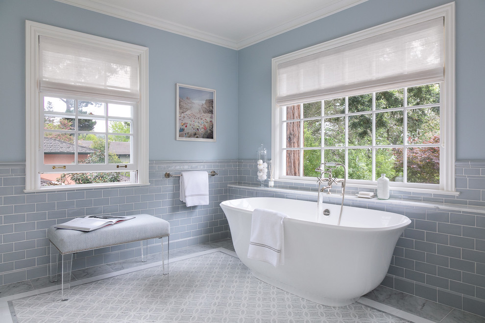 Photo of a traditional master bathroom in San Francisco with a freestanding tub, blue tile, subway tile, blue walls and grey floor.