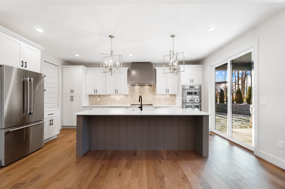 Inspiration for a mid-sized transitional l-shaped medium tone wood floor kitchen remodel in Cincinnati with an undermount sink, shaker cabinets, white cabinets, quartzite countertops, mosaic tile backsplash, stainless steel appliances, an island and white countertops