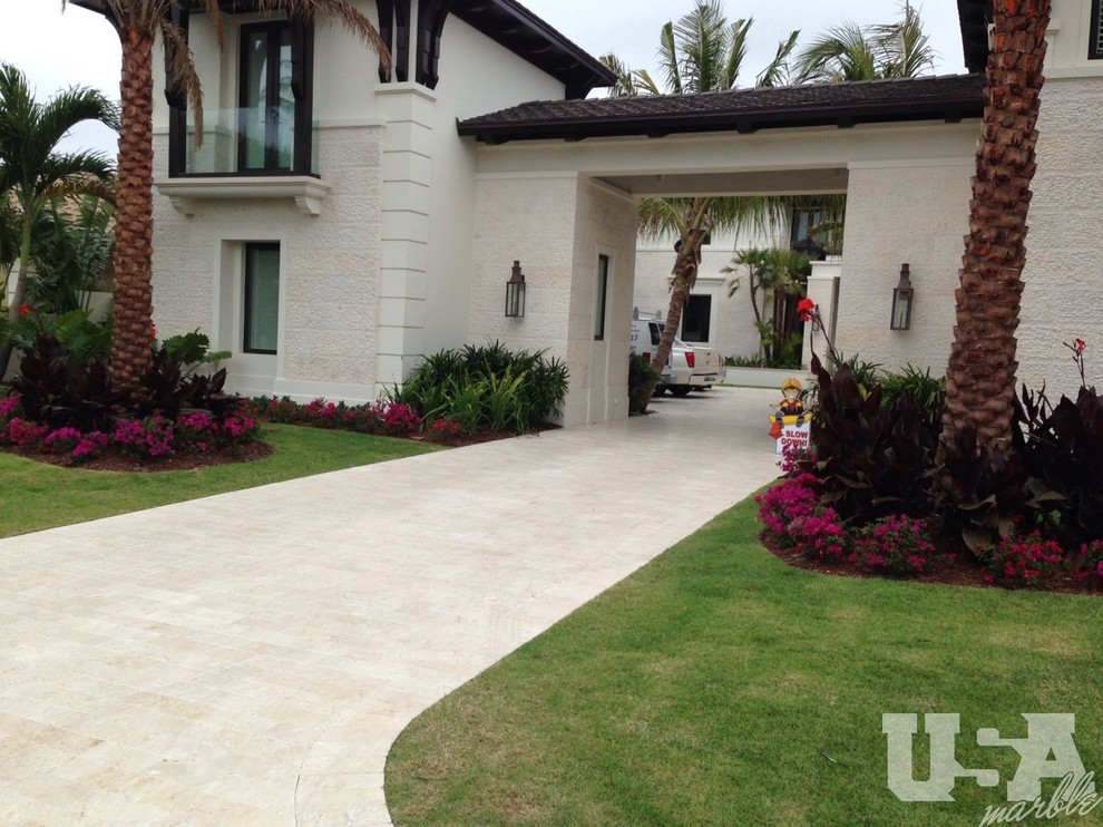 Photo of an expansive modern front yard patio in Miami with natural stone pavers.
