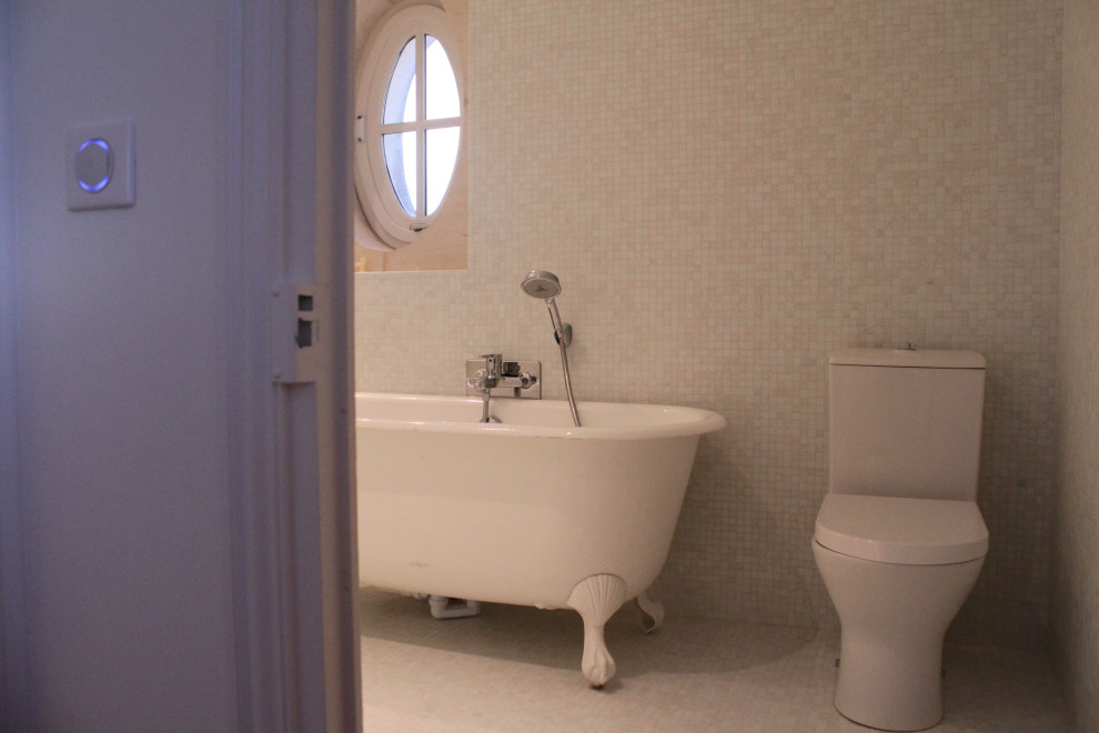 This is an example of a mid-sized midcentury kids bathroom in Other with a claw-foot tub, a one-piece toilet, white tile, mosaic tile, white walls, mosaic tile floors and white floor.