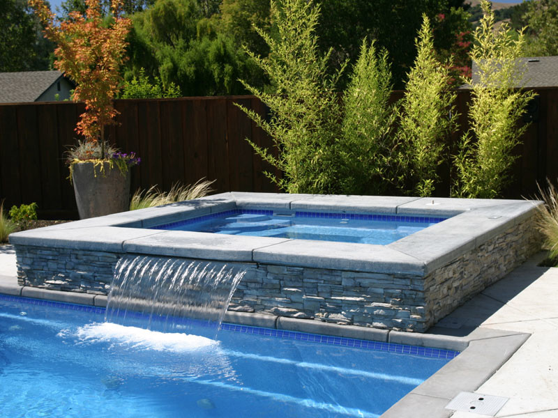 Example of a large transitional backyard concrete paver and rectangular hot tub design in Chicago
