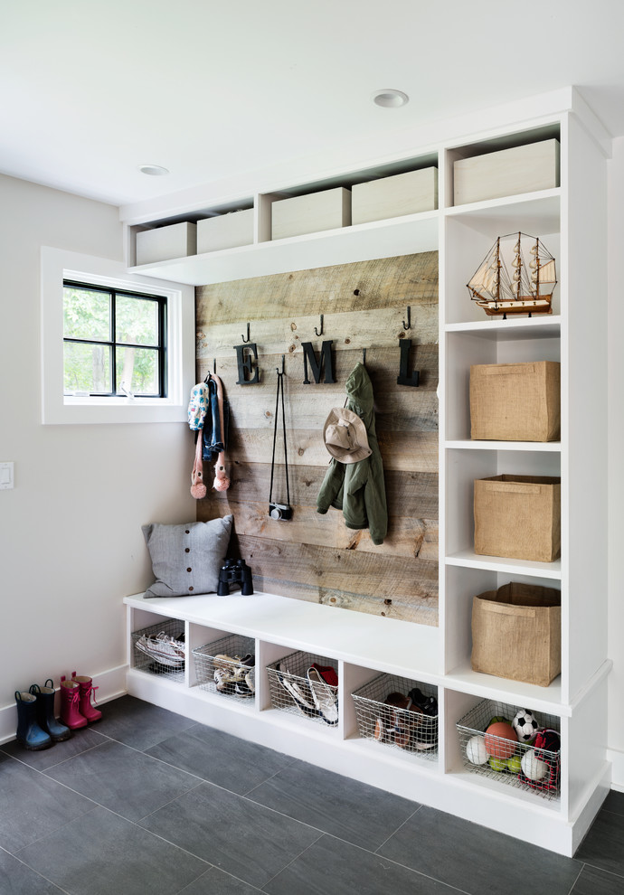 Beach style mudroom in New York with beige walls and grey floor.