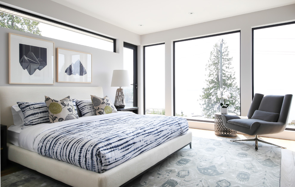 Example of a trendy light wood floor bedroom design in Vancouver with white walls and no fireplace