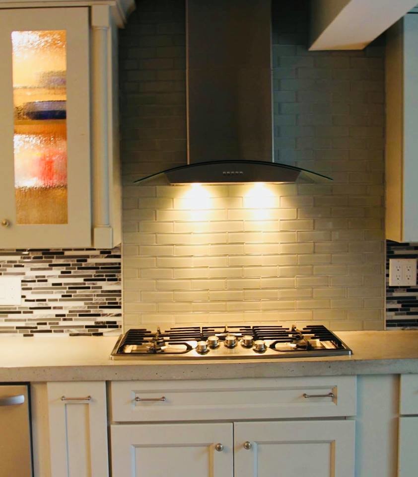 Mid-sized transitional galley medium tone wood floor and beige floor open concept kitchen photo with a double-bowl sink, recessed-panel cabinets, white cabinets, quartz countertops, multicolored backsplash, matchstick tile backsplash, stainless steel appliances, an island and beige countertops