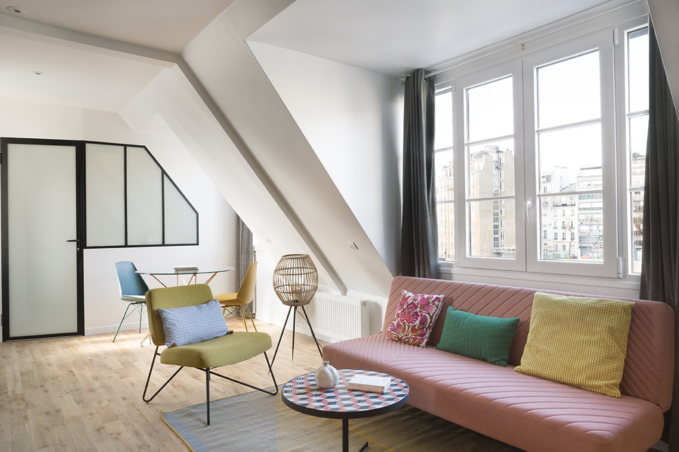 Design ideas for a small tropical loft-style living room in Paris with white walls, light hardwood floors and no fireplace.