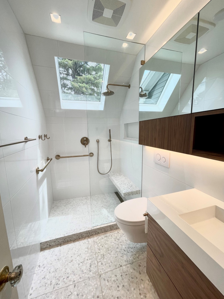 Идея дизайна: маленькая ванная комната в стиле модернизм с плоскими фасадами, темными деревянными фасадами, открытым душем, инсталляцией, белой плиткой, керамической плиткой, белыми стенами, полом из терраццо, раковиной с несколькими смесителями, белым полом, открытым душем, белой столешницей, сиденьем для душа, тумбой под одну раковину и подвесной тумбой для на участке и в саду