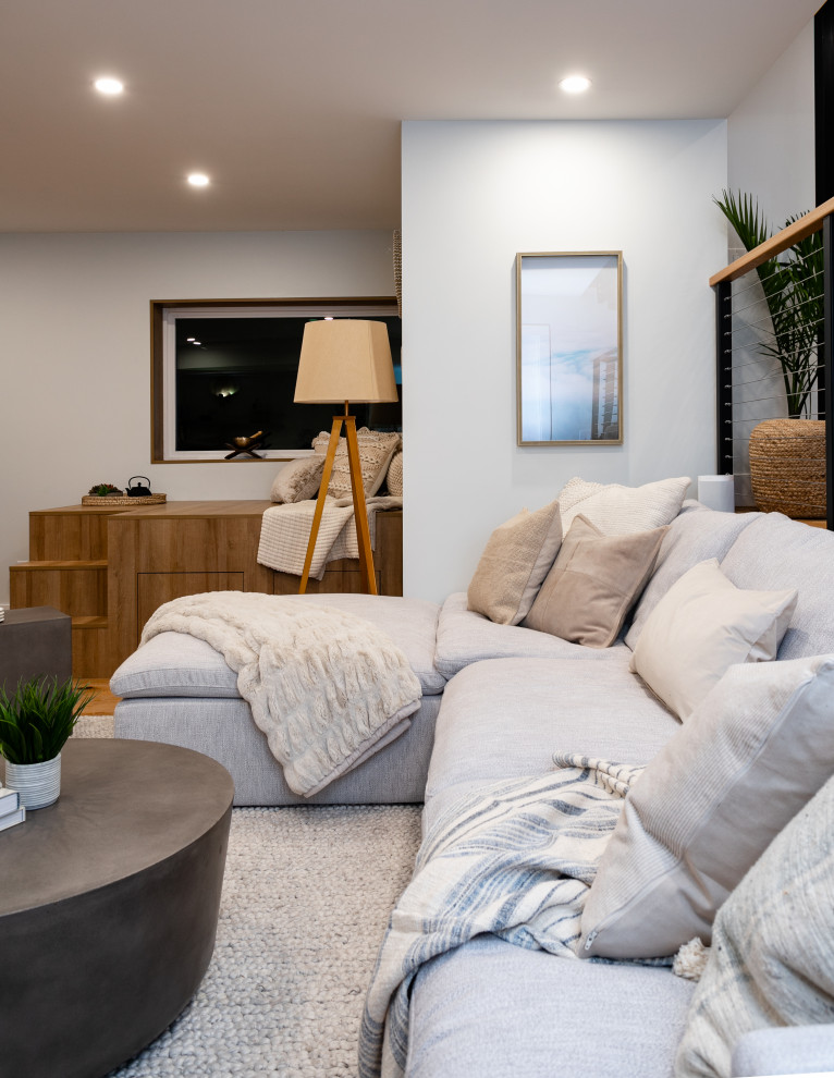 Idee per un grande soggiorno nordico aperto con angolo bar, pareti grigie, pavimento in legno massello medio, TV a parete e pavimento marrone