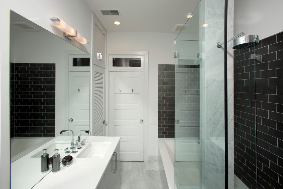 Inspiration for a mid-sized contemporary master bathroom in DC Metro with flat-panel cabinets, grey cabinets, an alcove shower, a one-piece toilet, black tile, gray tile, white tile, stone tile, marble floors, an undermount sink, solid surface benchtops, an alcove tub and white walls.