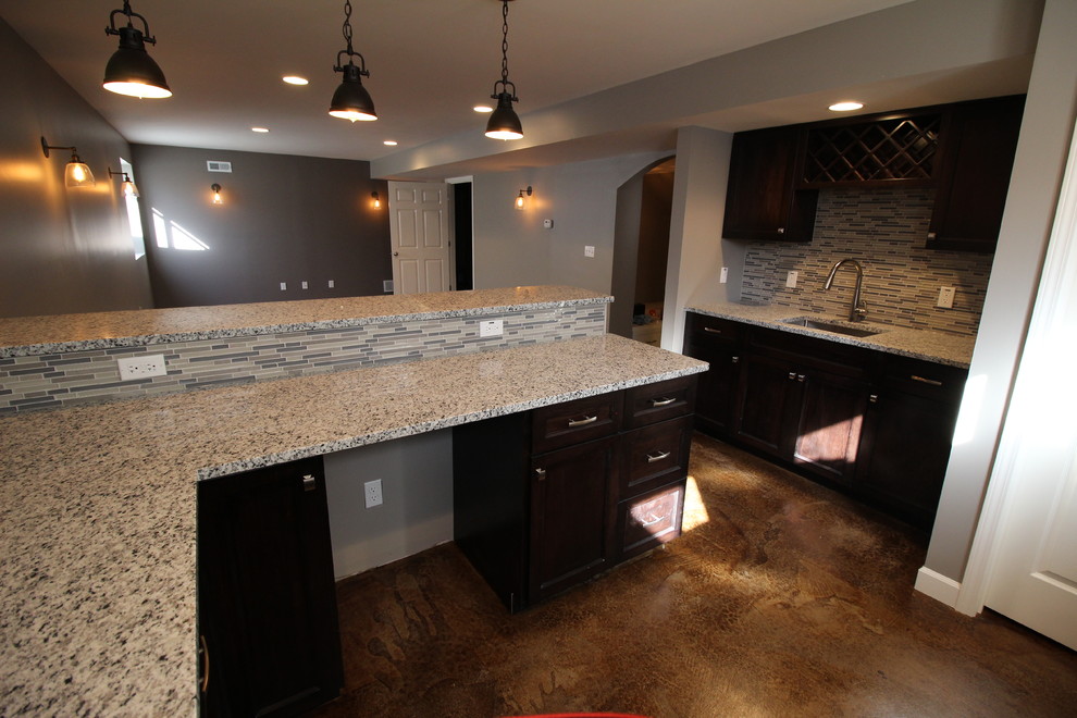 Large transitional open concept family room in St Louis with a home bar, grey walls, concrete floors and brown floor.