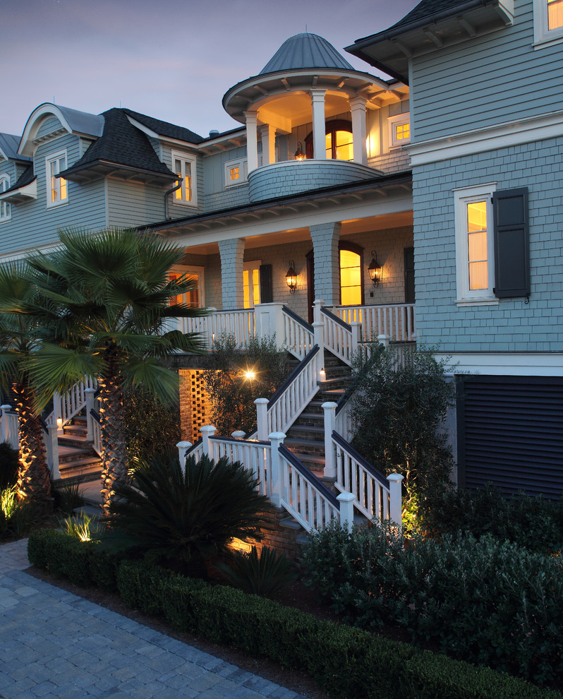 Expansive beach style two-storey grey house exterior in Charleston with wood siding and a mixed roof.