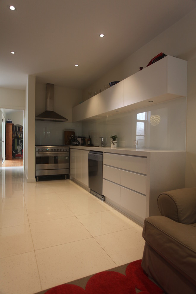 Photo of a small contemporary single-wall eat-in kitchen in Melbourne with an undermount sink, white cabinets, white splashback, glass sheet splashback, stainless steel appliances and no island.