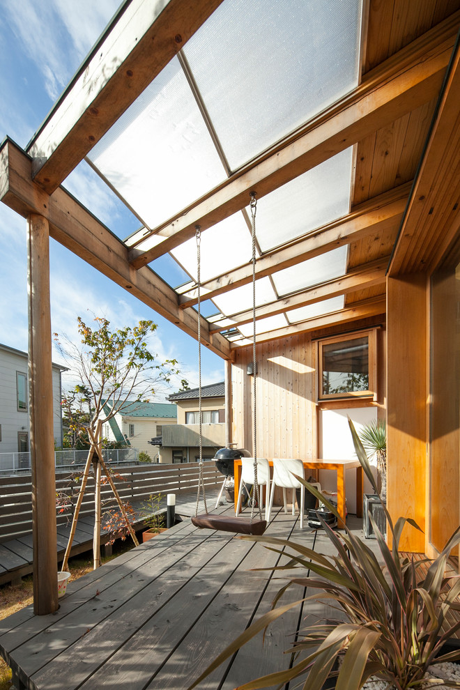 This is an example of a contemporary side yard deck in Other with a pergola.