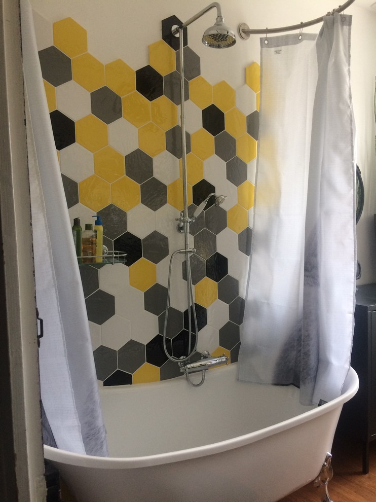 This is an example of a mid-sized midcentury master bathroom with a claw-foot tub, a shower/bathtub combo, a wall-mount toilet, yellow tile, white walls, bamboo floors, a vessel sink and wood benchtops.
