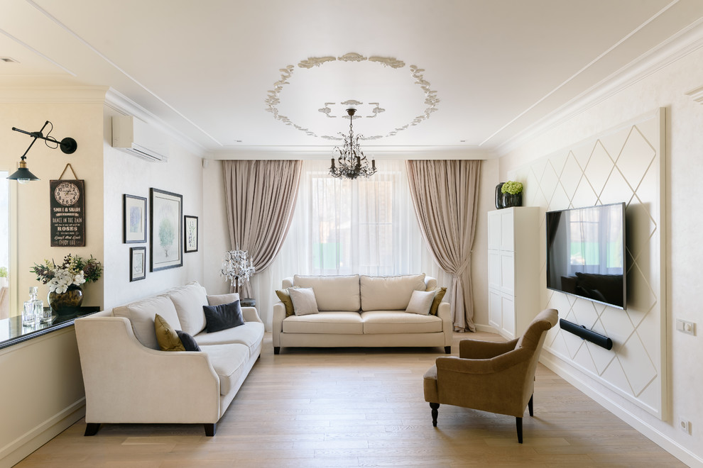 This is an example of a transitional open concept living room in Moscow with white walls, light hardwood floors, a wall-mounted tv and beige floor.
