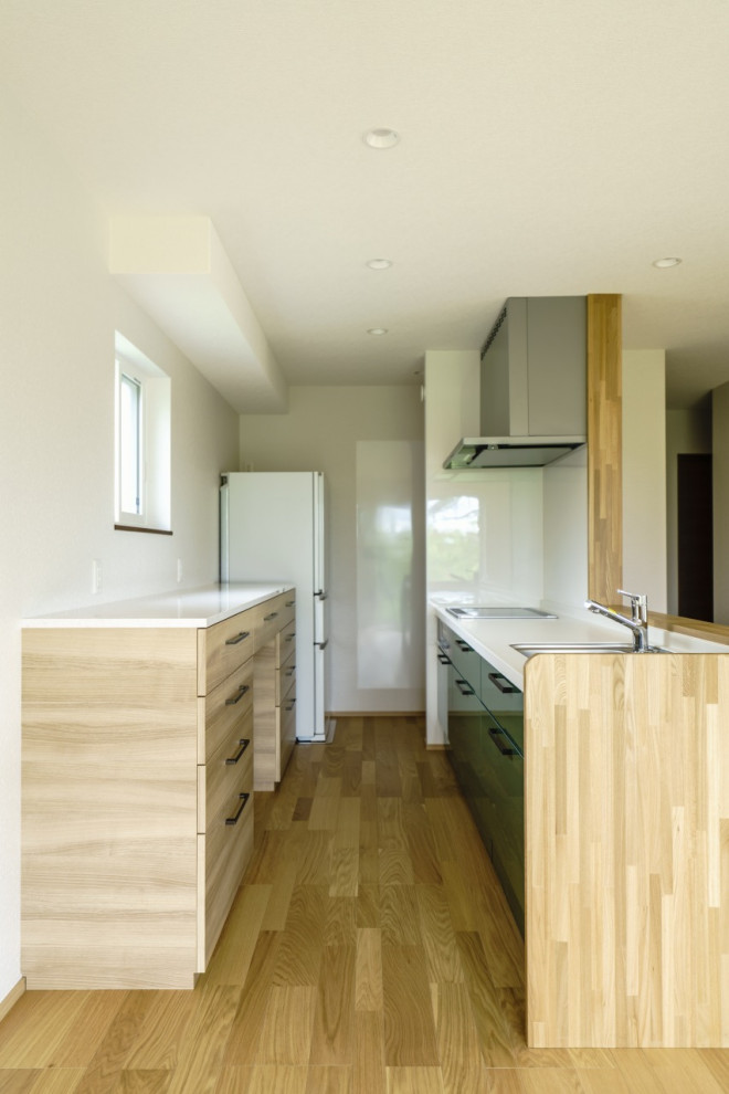 Idéer för mellanstora funkis linjära vitt kök, med en integrerad diskho, luckor med profilerade fronter, bruna skåp, bänkskiva i koppar, vitt stänkskydd, ljust trägolv och brunt golv