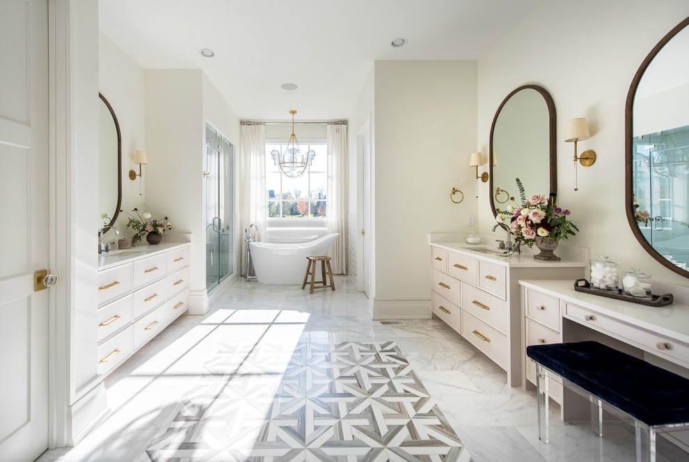 Inspiration for a large transitional master wet room bathroom in Indianapolis with beige cabinets, a freestanding tub, a two-piece toilet, white tile, ceramic tile, white walls, marble floors, a drop-in sink, quartzite benchtops, white floor, a hinged shower door and recessed-panel cabinets.