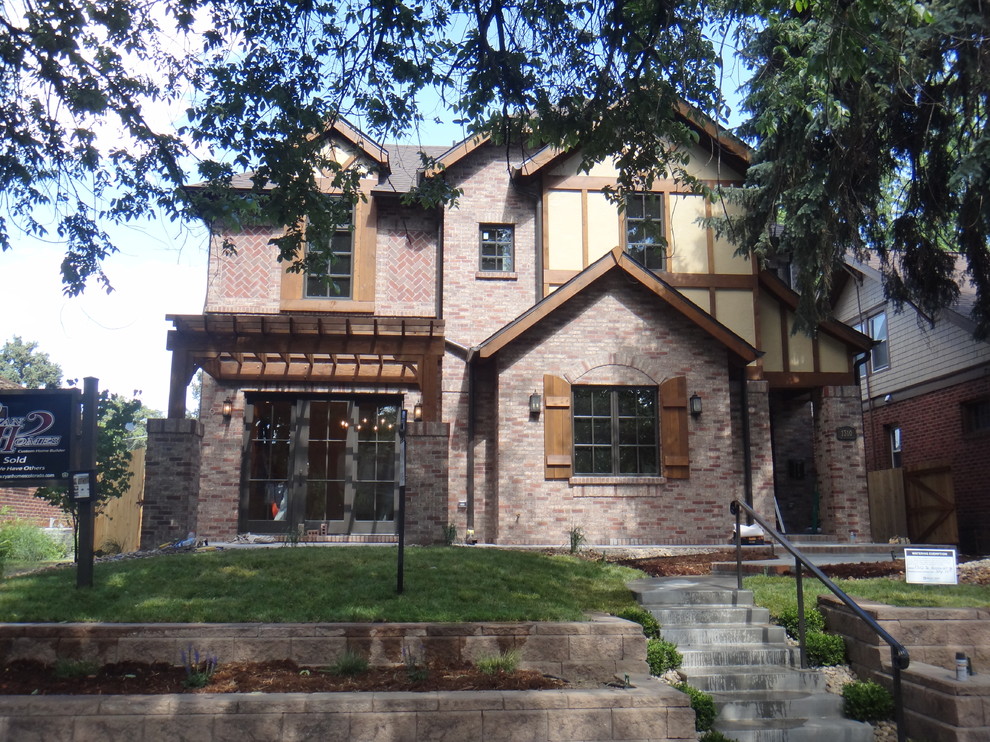 Example of a classic red two-story stucco exterior home design in Denver