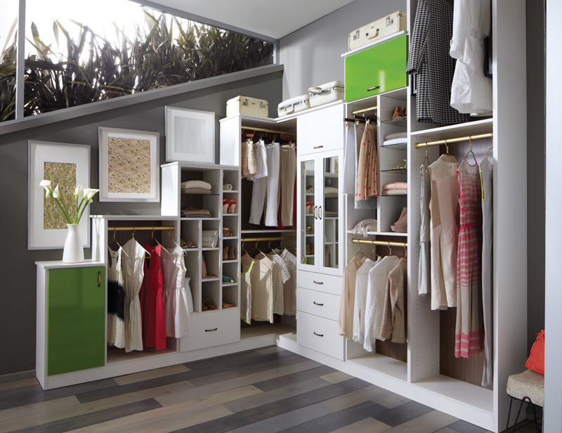 This is an example of a mid-sized contemporary women's dressing room in Detroit with open cabinets, white cabinets, medium hardwood floors and grey floor.