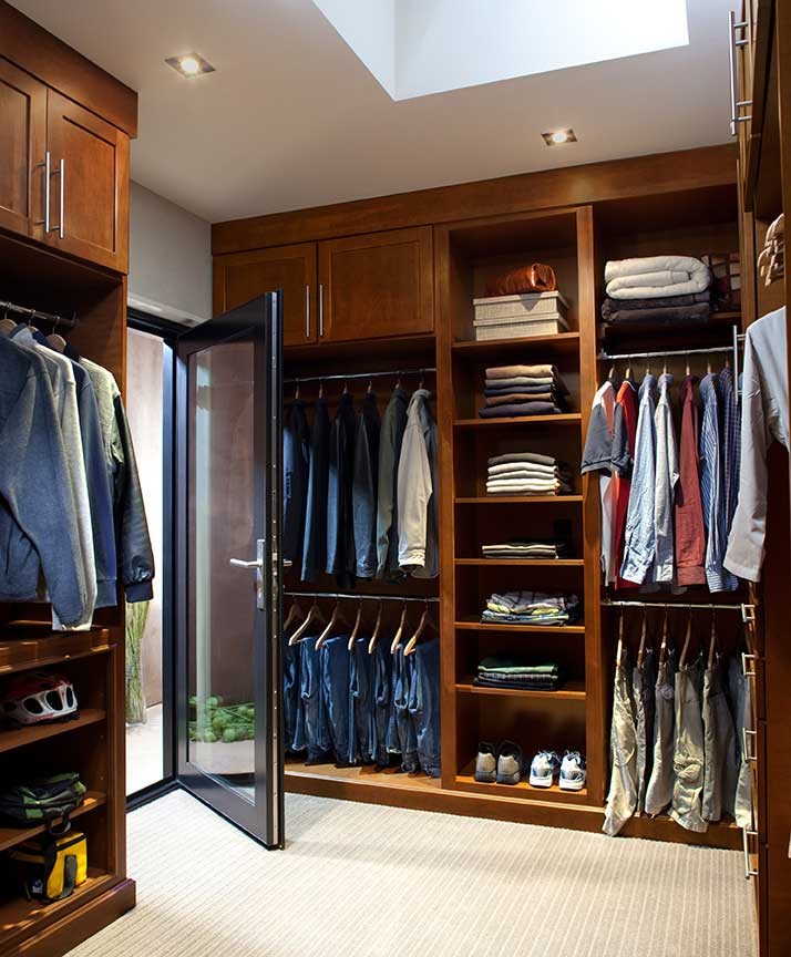 Inspiration for a large traditional men's walk-in wardrobe in San Diego with shaker cabinets, dark wood cabinets and carpet.