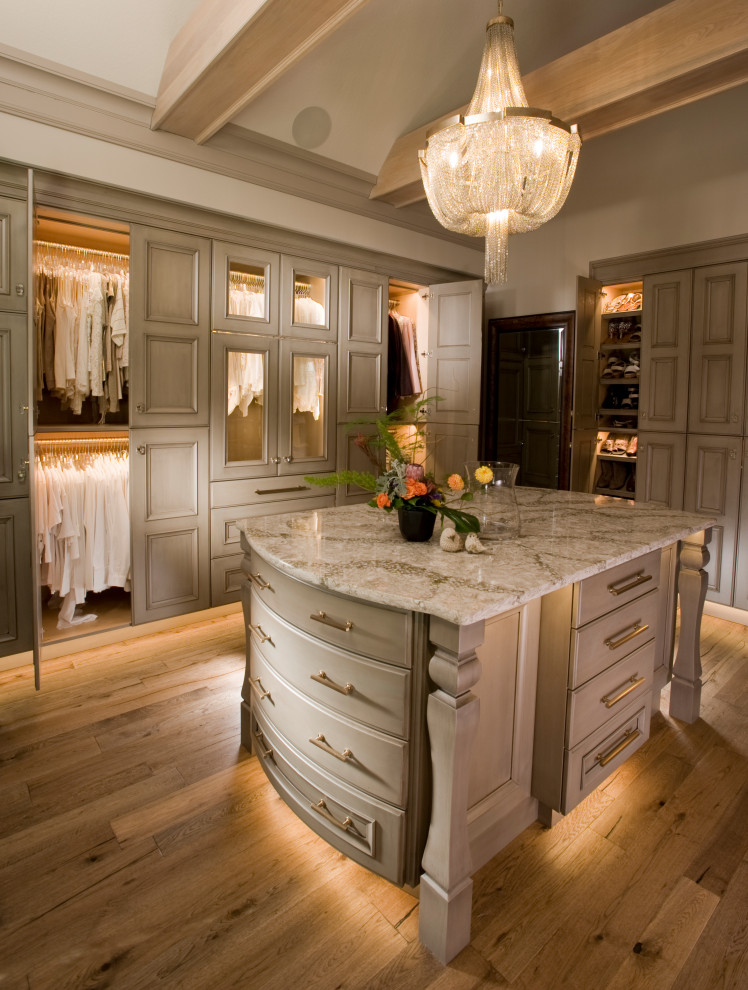 Photo of a large traditional gender-neutral walk-in wardrobe in Wichita with recessed-panel cabinets, beige cabinets, medium hardwood floors and brown floor.