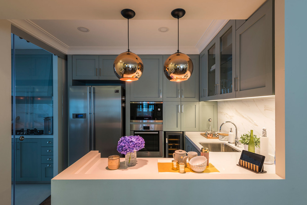 This is an example of a small transitional u-shaped eat-in kitchen in Singapore with an undermount sink, shaker cabinets, quartz benchtops, white splashback, porcelain splashback, stainless steel appliances and vinyl floors.