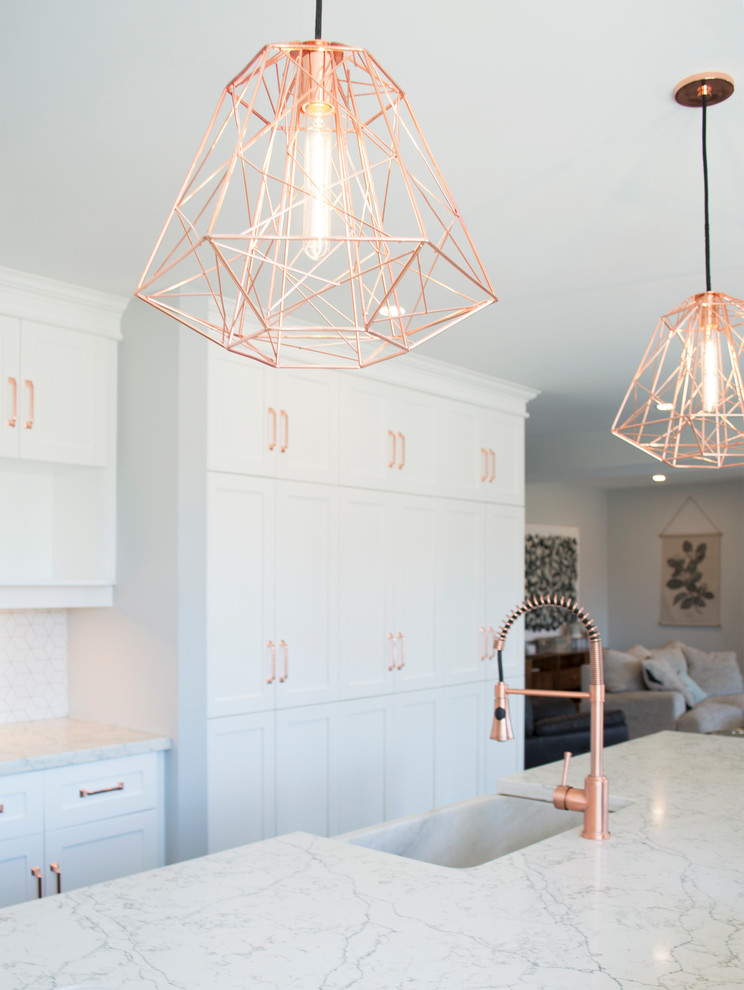Inspiration for a transitional medium tone wood floor and gray floor open concept kitchen remodel with a farmhouse sink, recessed-panel cabinets, quartz countertops, white backsplash, mosaic tile backsplash, stainless steel appliances, an island, white countertops and white cabinets