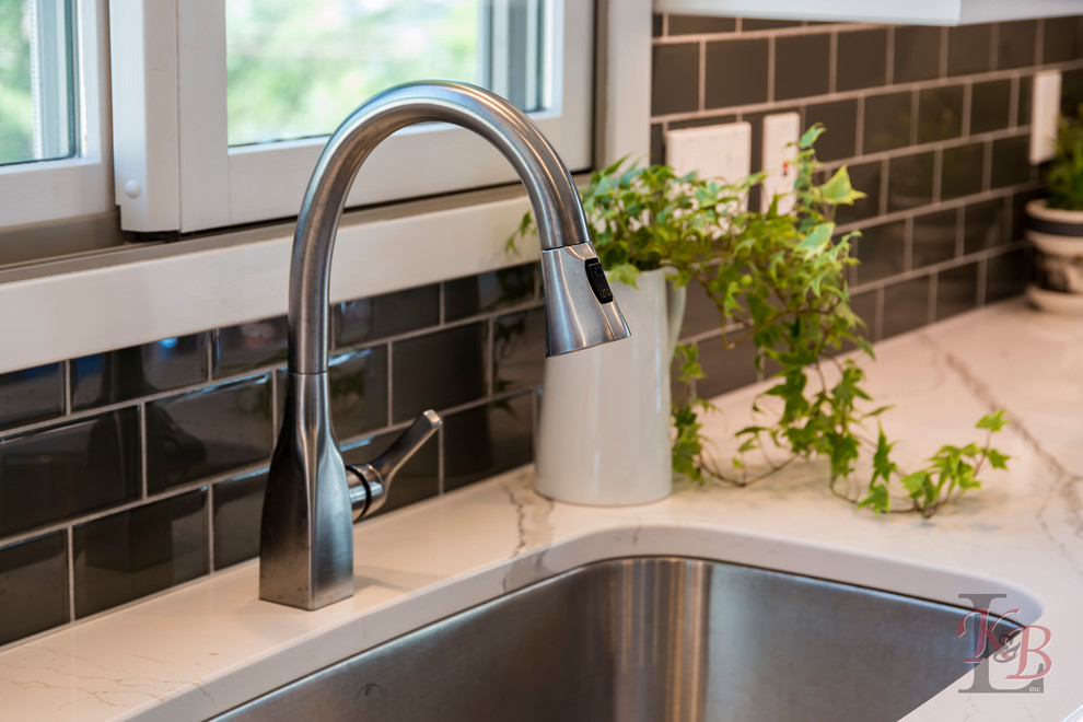 Eat-in kitchen - mid-sized transitional porcelain tile and brown floor eat-in kitchen idea with an undermount sink, recessed-panel cabinets, white cabinets, quartz countertops, gray backsplash, subway tile backsplash, stainless steel appliances, an island and white countertops