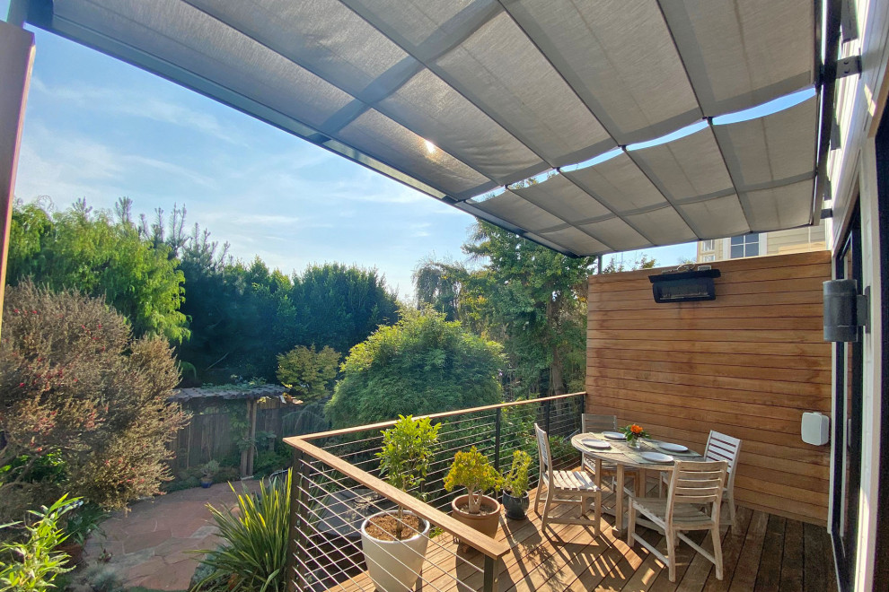 This is an example of a modern back first floor wire cable railing terrace in San Francisco with a pergola.